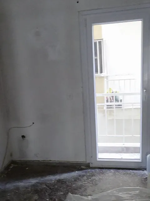 Ο χώρος της κουζίνας πριν: γυμνοί τοίχοι και μπαλκονόπορτα