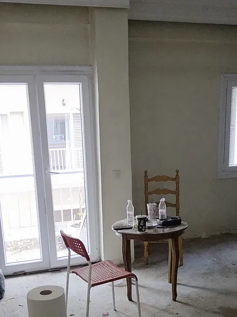 Το σαλόνι πριν από την ανακαίνιση: γυμνό δάπεδο και πρόχειρα έπιπλα